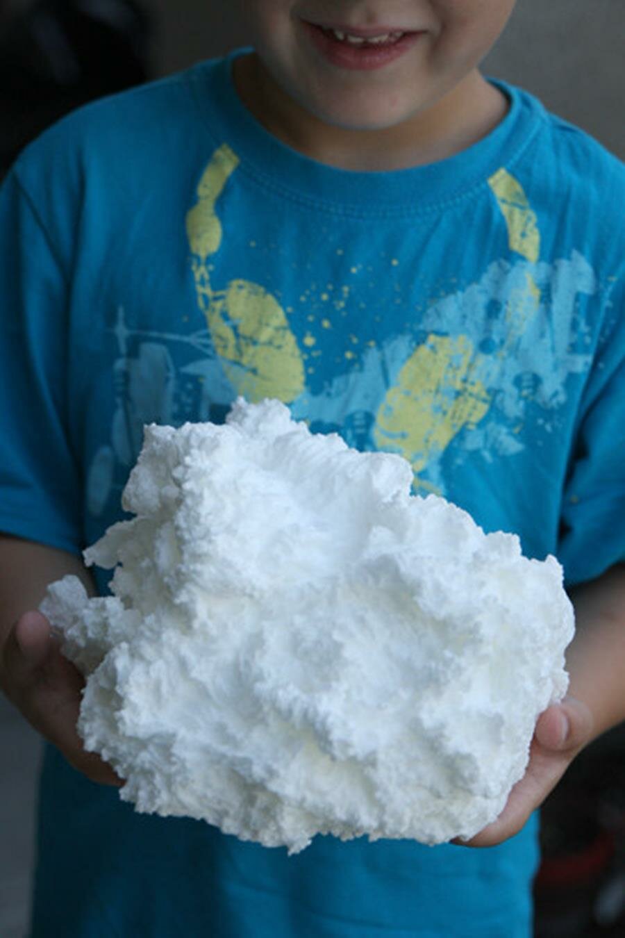 un nuage de savon tenu dans les main d'un garçon